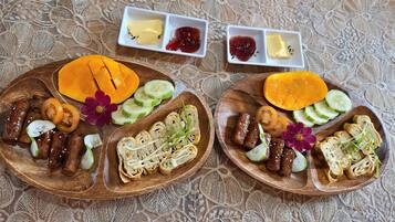 Two wooden plates with food and condiments.