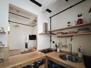 A modern kitchen with a wooden countertop, stainless steel sink, and a gas stove. - 1910 Pera Apartment • 2BR Home • Istiklal & Galata (İstanbul)