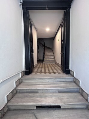En trappa som leder upp till en liten plattform, med en spiraltrappa synlig i bakgrunden.