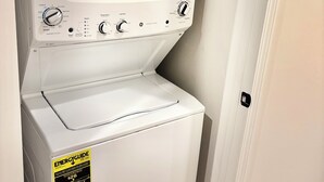 En vit tvättmaskin och torktumlare i ett, med knappar för inställningar, en startknapp och en energimärkning.