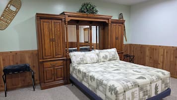 Une chambre à coucher avec un lit à baldaquin, une armoire en bois, un petit tabouret et un miroir.