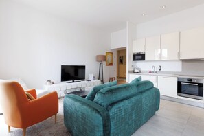 Ein modernes Wohnzimmer mit einer Couch, einem Fernseher und einem Couchtisch.