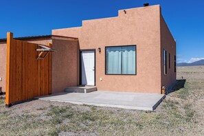 A single-story building with a wooden gate, a door, and a window.