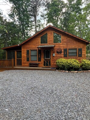 A wooden cabin with a porch, a front door, and a small bench. - Great Escape 2, charming 2 bed 2 bath cabin in Murphy, North Carolina (Murphy)