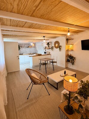 Eine moderne Küche mit weißen Schränken, einer Holzarbeitsplatte und einem Essbereich mit Tisch und Stühlen.