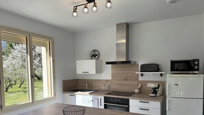 A modern kitchen with a large window, a microwave, a toaster, and a dishwasher. - Le Canigou - FUILLA - Vacation Rental (FUILLA)