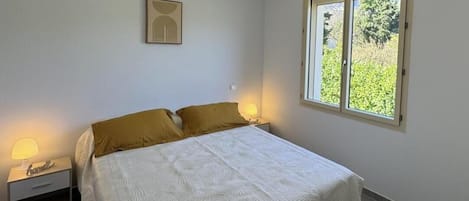 Une chambre à coucher avec un lit, des lampes de chevet, une fenêtre et un luminaire fixé au mur.