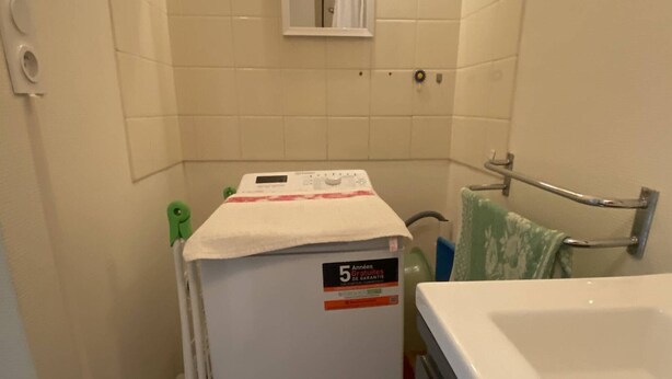 A compact bathroom with a white bathtub, a small sink, and a towel rack. - T2 apartment, clear view - 4 guests (Canet-en-Roussillon)