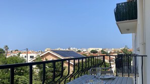A balcony with a table and chairs, overlooking a residential area with houses and solar panels. - T2 apartment, clear view - 4 guests (Canet-en-Roussillon)