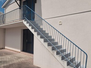 A building with a concrete staircase, a metal railing, and a black door. - Central apartment with balcony - 4 guests (Fouras)