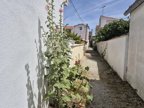A narrow alleyway with a white wall on one side and a building on the other. - Central apartment with balcony - 4 guests (Fouras)