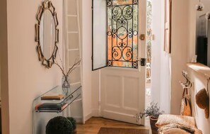 A room with a white door, a glass display unit, a mirror, and a fireplace. - Superbe maison en pierre (Sauternes)