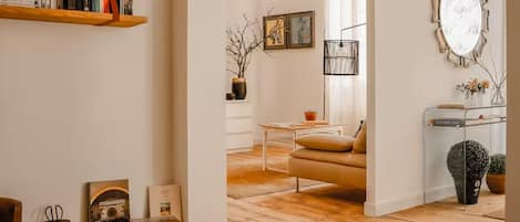 A cozy living room with a sofa, a coffee table, and a bookshelf.