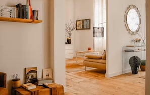 A cozy living room with a sofa, a coffee table, and a bookshelf.