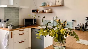 Eine moderne Küche mit Mikrowelle, Radio und einer Vase mit Blumen auf der Arbeitsfläche.