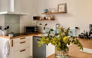 Eine moderne Küche mit Mikrowelle, Radio und einer Vase mit Blumen auf der Arbeitsfläche.