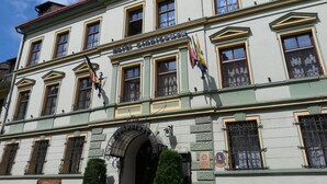 A historic building with multiple windows, a central entrance, and flags. - Sighisoara Hotel (Sighisoara)