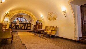 A cozy interior with a reception desk, a sofa, and a rug. - Sighisoara Hotel (Sighisoara)