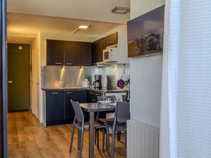 A compact kitchen with dark cabinets, a stainless steel microwave, and a coffee maker. - Renovated apartment, ideal location - 6 guests (Plagne Bellecôte)