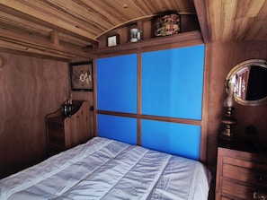 A bedroom with a wooden ceiling, a bed with a white quilt, a dresser, a mirror, and a blue panel wall. - Unique house in the heart of Fouras - 2 guests (Fouras)