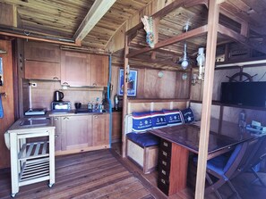 Eine kleine Küche mit Holzschränken, einem Spülbecken und einer Arbeitsplatte.