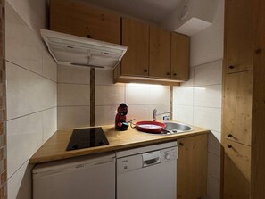 A compact kitchen with a dishwasher, a red kettle, and a sink. - Apartment with station view - 2 guests (Valmorel)