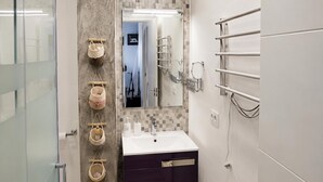 A modern bathroom with a glass shower enclosure, a white sink with a purple vanity, and a tiled backsplash. - Apartment with AC & WiFi - 3 guests near beach (Platja d'Aro)