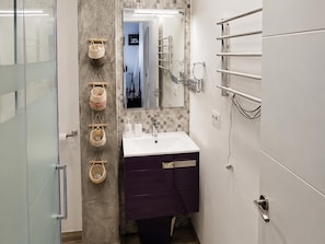 A modern bathroom with a glass shower enclosure, a white sink with a purple vanity, and a tiled backsplash. - Apartment with AC & WiFi - 3 guests near beach (Platja d'Aro)
