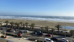 A coastal view with a parking lot, palm trees, and a beach. - Apartment with sea view terrace - 4 guests (Canet-Plage)