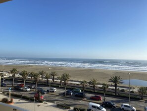 A coastal view with a parking lot, palm trees, and a beach. - Apartment with sea view terrace - 4 guests (Canet-Plage)