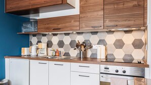 A modern kitchen with wooden cabinets, a microwave, a coffee maker, and a Siemens oven.