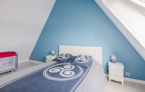 A bedroom with a bed, two bedside tables, a nightstand, a red storage unit, and a wall with a blue accent. - 2 bedroom gorgeous apartment in Lezardrieux (Lezardrieux)