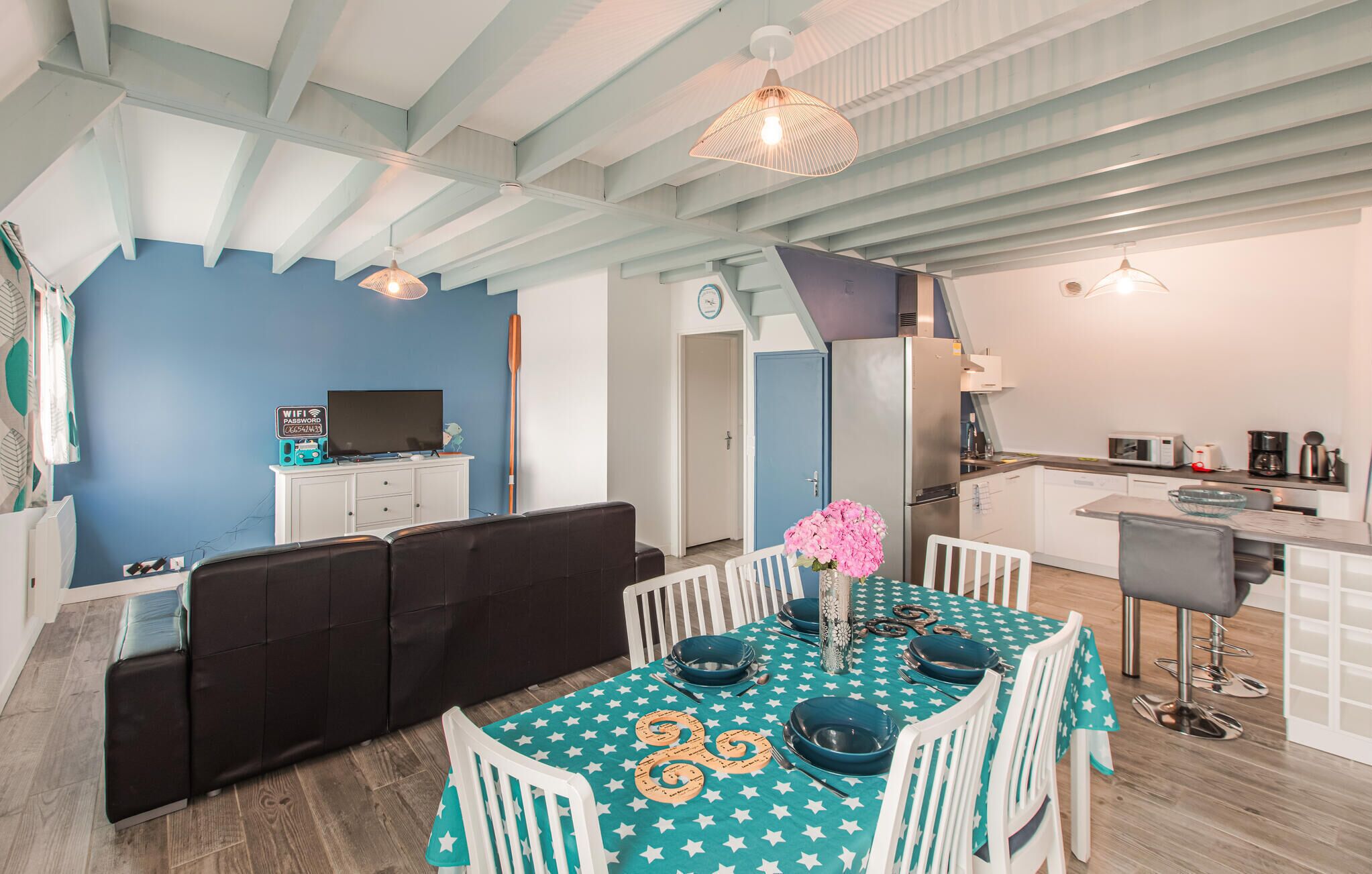 A modern living space with a dining area, kitchen, and seating area.