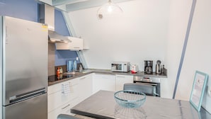 Una kitchenette compacta equipada con refrigerador, microondas, tostadora y cafetera.