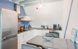A compact kitchenette with a built-in refrigerator, microwave, toaster, and coffee maker. - 2 bedroom gorgeous apartment in Lezardrieux (Lezardrieux)
