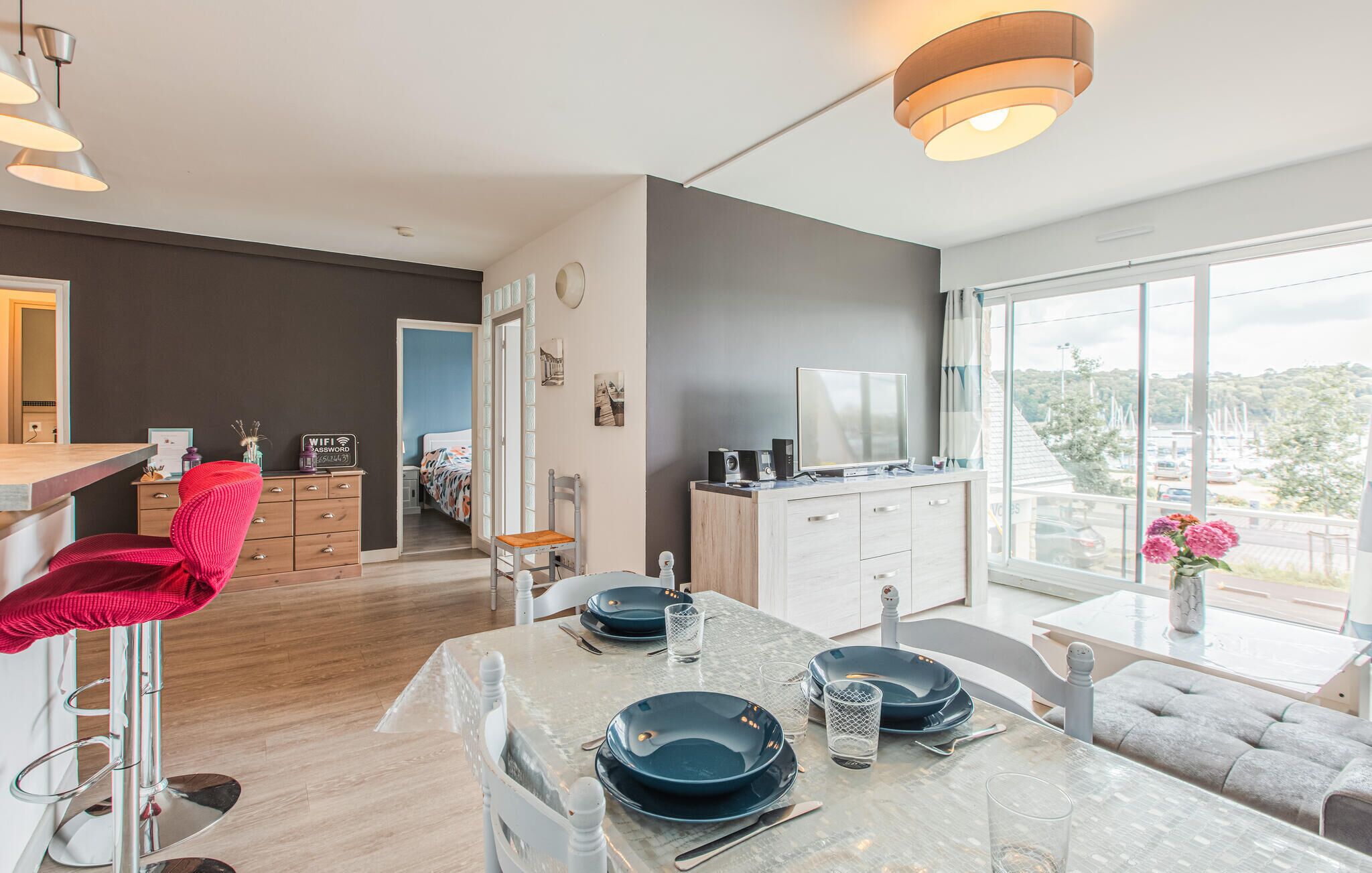 Une cuisine moderne avec un coin repas, un téléviseur et une vue sur le port de plaisance.