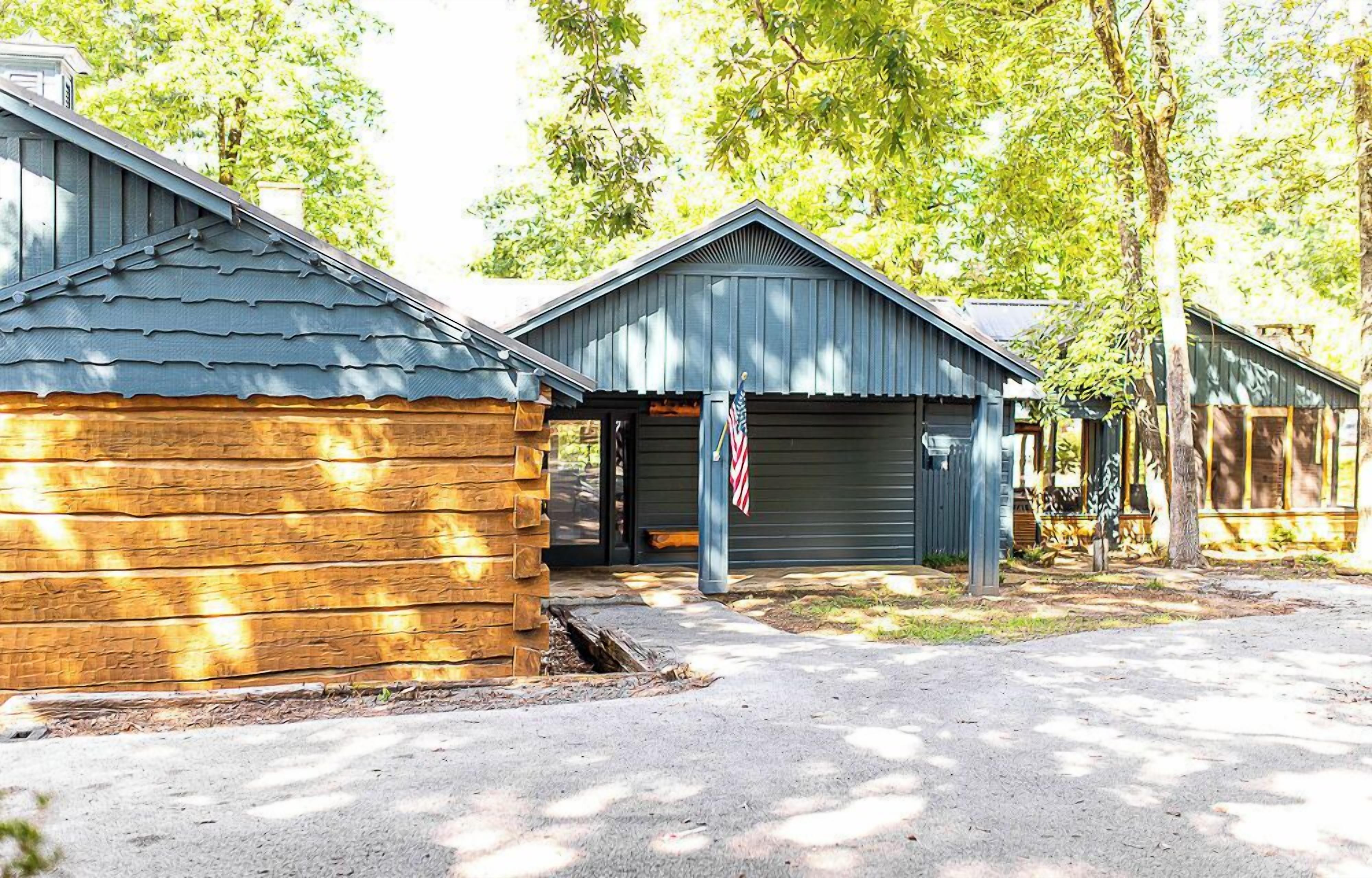 A row of cabins with a wooden exterior and metal roofs, each with a garage door.
