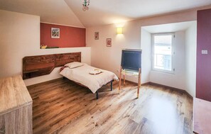Quarto com cama de madeira, lousa e janela.