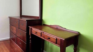A wooden dresser with drawers and a mirror, against a green wall. - Ringwood 4BR House near Eastland + Parking (Ringwood)