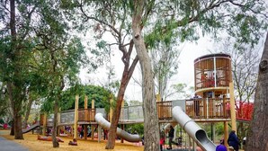 A playground with slides, climbing structures, and a wooden playhouse. - Ringwood 4BR House near Eastland + Parking (Ringwood)