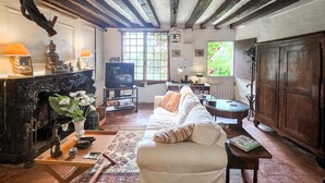 Una sala de estar acogedora con chimenea, televisor, sofá y comedor con mesa y sillas.