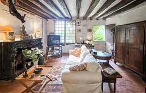 A cozy living room with a fireplace, a television, a sofa, and a dining area with a table and chairs. - 1 bedroom pet friendly home in Bourre (Bourre)