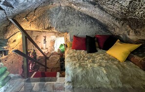 A cave-like room with a bed, pillows, and a staircase leading to another area. - 1 bedroom pet friendly home in Bourre (Bourre)