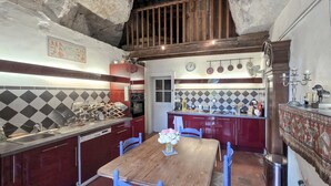 Una cocina con mesa y sillas de madera, un lavamanos y una estufa.