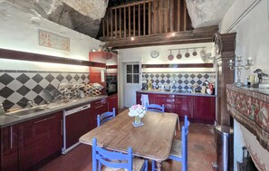 A kitchen with a wooden table and chairs, a sink, and a stove. - 1 bedroom pet friendly home in Bourre (Bourre)