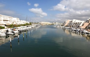 A marina with boats docked, surrounded by modern buildings with balconies. - 1 bedroom beautiful apartment in Le Grau-du-Roi (Le Grau-du-Roi)