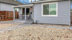 Ett bostadshus med en inglasad veranda, siffran ’397’ på väggen och en grusuppfart.