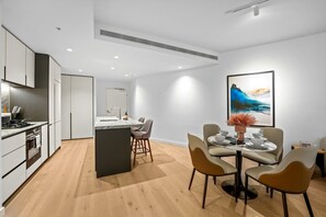 Eine moderne Küche mit Essbereich, einer Kochinsel und einem zeitgenössischen Gemälde an der Wand.