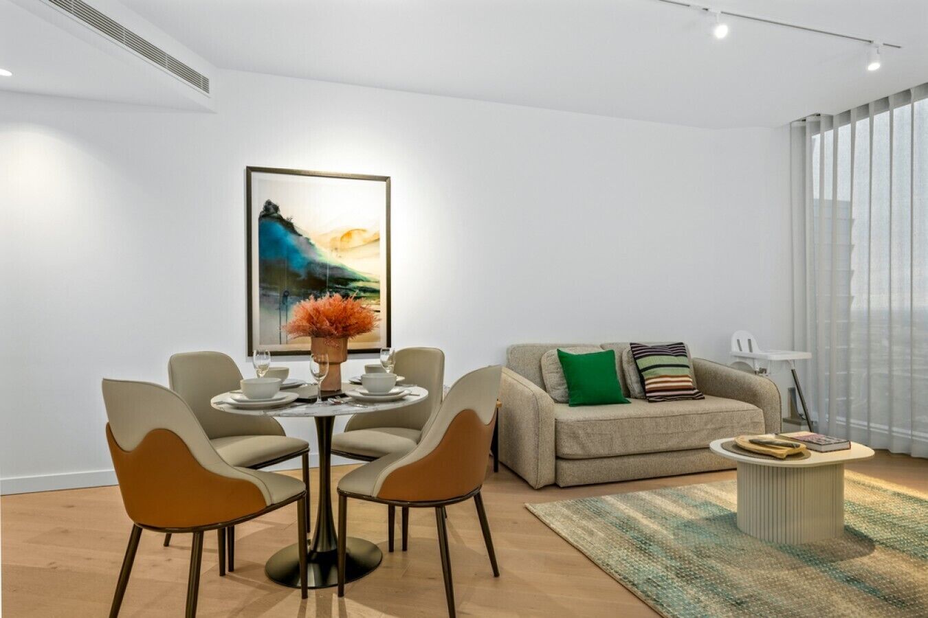 A modern living room with a dining table, chairs, a sofa, and a coffee table.