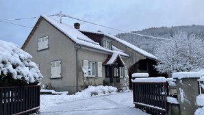 A house with a snow-covered roof and a gated entrance.